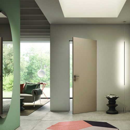 Interior moderno con puerta enrasada Scrigno Filo44 integrada en la pared, de diseño minimalista y sin marcos visibles, que aporta continuidad estética y un acabado elegante y contemporáneo al espacio.