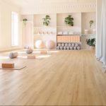Suelo laminado Finfloor Original AC5 en tono madera clara instalado en una sala luminosa y minimalista, con acabado natural, textura realista y alta resistencia al desgaste, ideal para espacios modernos y elegantes.
