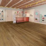 Suelo laminado Finfloor XL en espacio comercial moderno, acabado roble natural oscuro con lamas extragrandes, alta resistencia AC6 y protección frente al agua, ideal para zonas de alto tránsito.