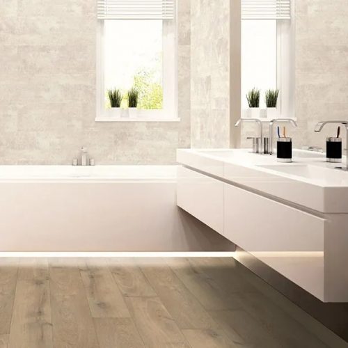 Suelo laminado de resina Flint HI FLOOR AC6 instalado en baño moderno con acabado efecto madera en tono gris cálido, resistente a la humedad y de alta durabilidad.